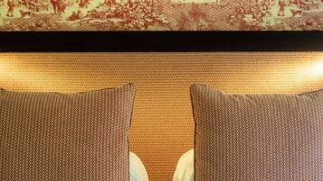 A bed with a patterned headboard and two pillows.