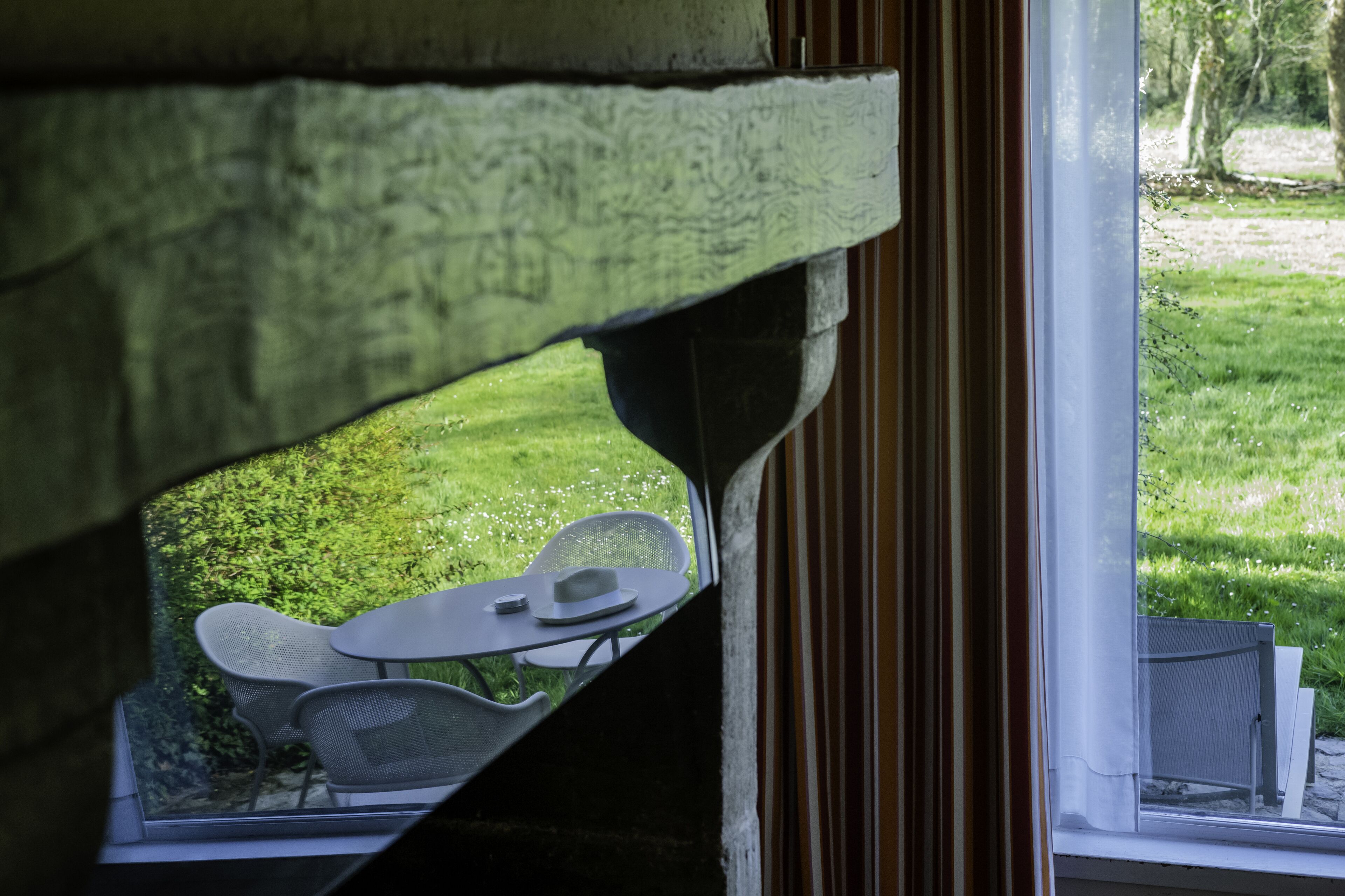 A view through a window with a table and chairs outside.