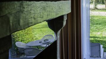 A view through a window with a table and chairs outside.