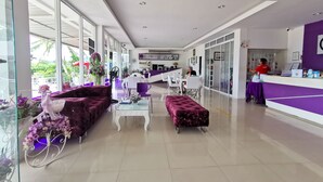 A modern hotel lobby with a reception desk, seating area, and large windows. - Phet Cha-am Plaza & Resort (Cha-am)