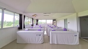A conference room with white tables, purple chair covers, and large windows. - Phet Cha-am Plaza & Resort (Cha-am)