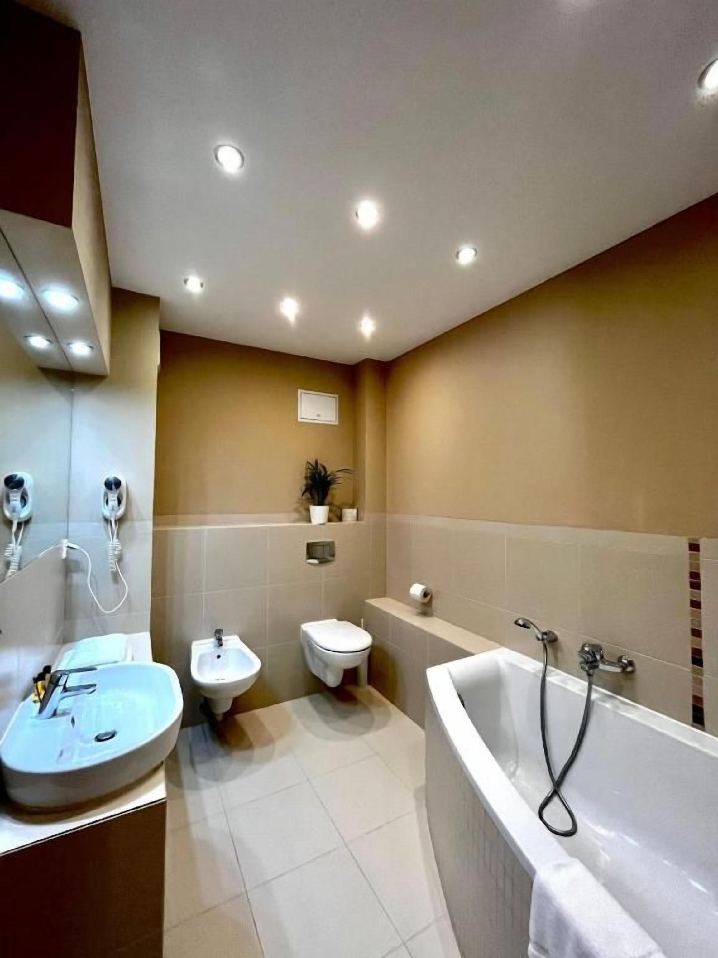 Et moderne badeværelse med badekar, vask og bidet.