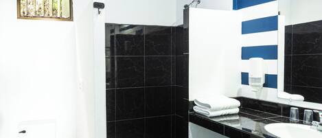 A bathroom with a shower, toilet, and sink.