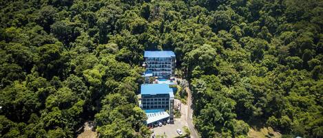 Vista aérea de un hotel rodeado de bosque denso.
