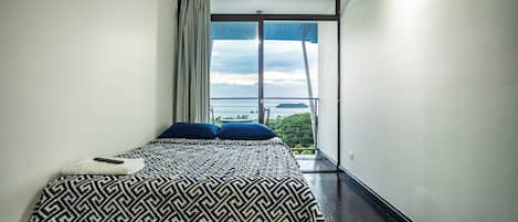 Una camera da letto con un letto grande, vista all'esterno e una finestra con tende.