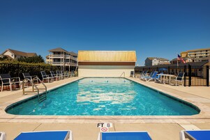 Una piscina al aire libre de temporada, sombrillas
