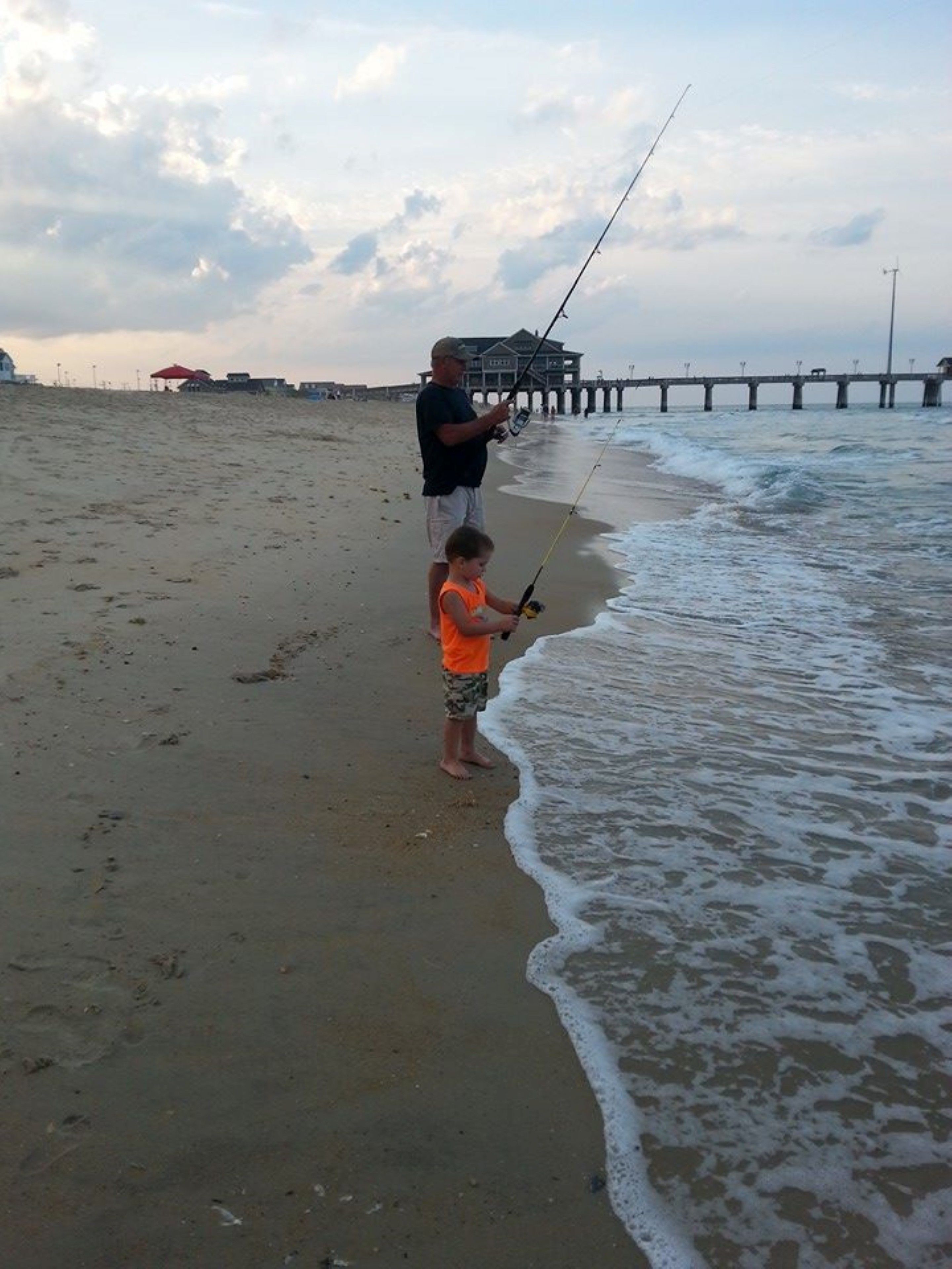 A beach scene with a pier in the background.