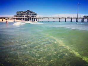 A beach house with a pier extending into the ocean. - Dolphin Oceanfront Motel (Nags Head)
