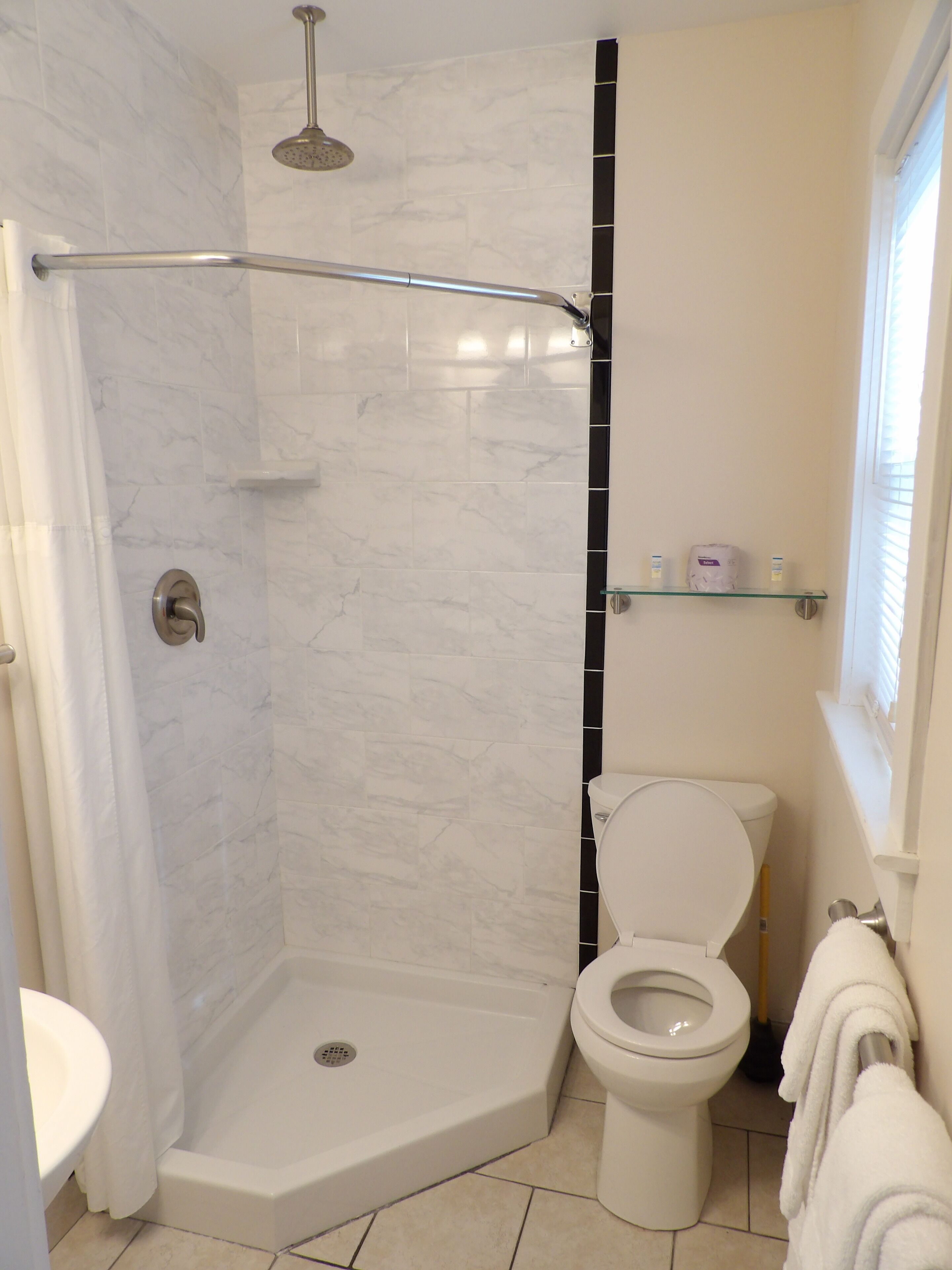 Ein Badezimmer mit Dusche, Toilette und Waschbecken.
