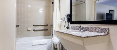A modern bathroom with a walk-in shower, a bathtub, a vanity with a sink, and a large mirror.