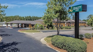 A Quality Inn hotel with a covered parking area, a landscaped entrance, and a building with multiple roofs. - Quality Inn Pinehurst Area (Aberdeen)