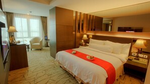 Une chambre d’hôtel avec un grand lit, des tables de chevet, un bureau et une chaise.