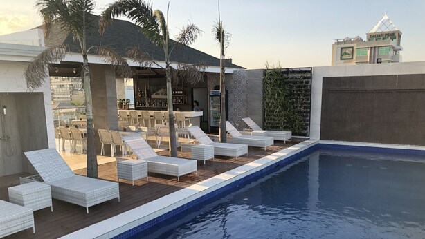 A pool area with lounge chairs and a bar. - Apollonia Royale Hotel (Angeles City)