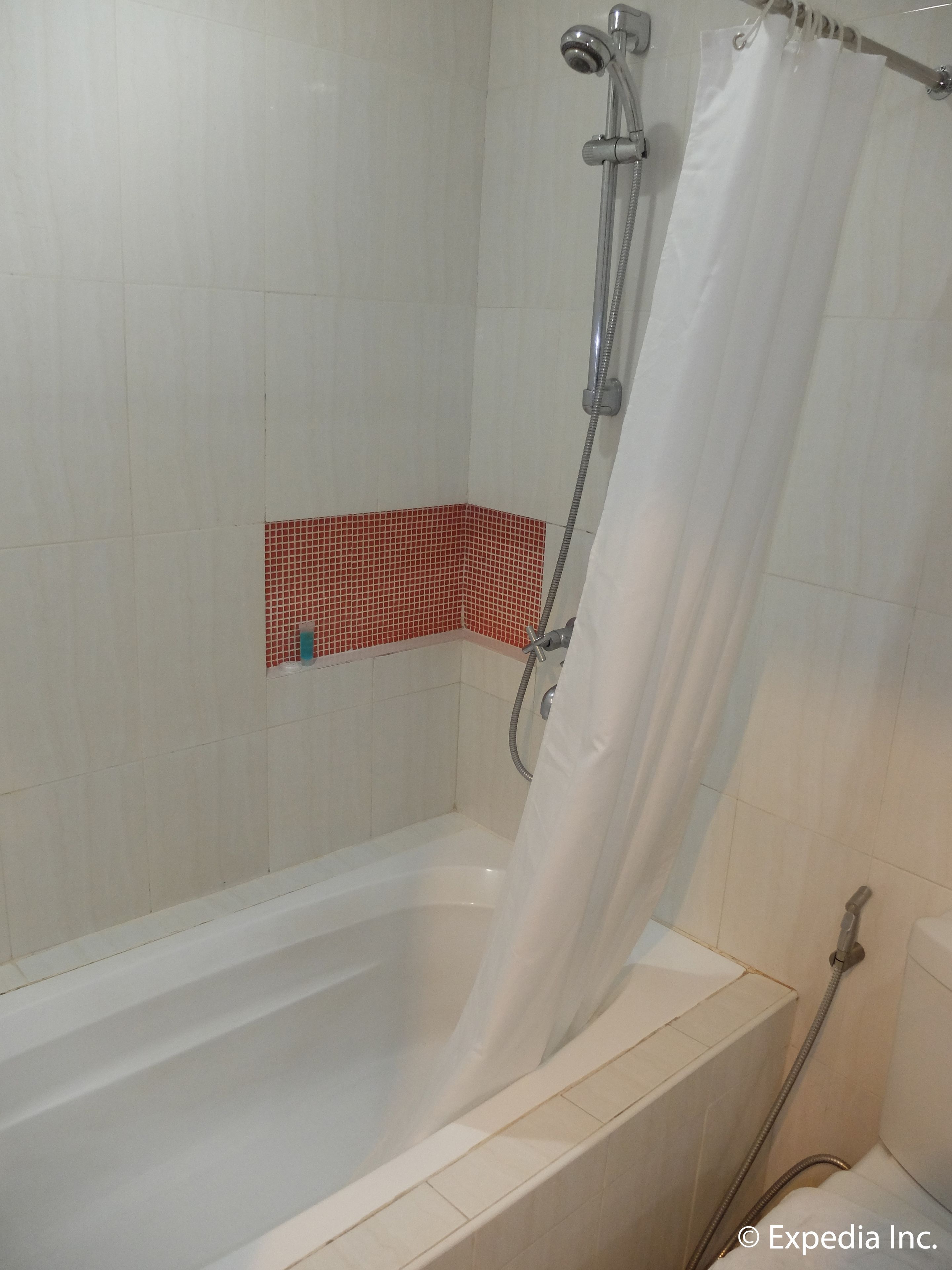 A shower area with a bathtub, a showerhead, and a curtain.