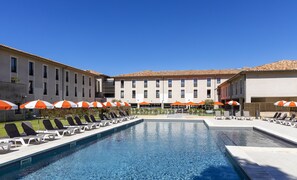 季节性开放的室外游泳池，池畔遮阳伞，日光浴躺椅