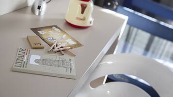 A desk with a notebook, a pen, and a teapot.