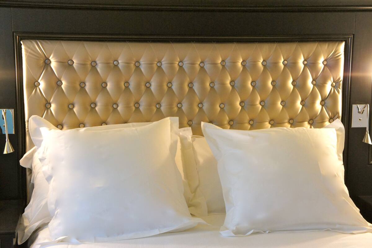 A bed with a tufted headboard and two pillows.