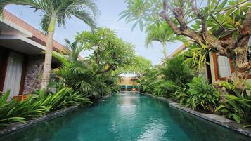 Una piscina al aire libre, sombrillas, sillones reclinables de piscina