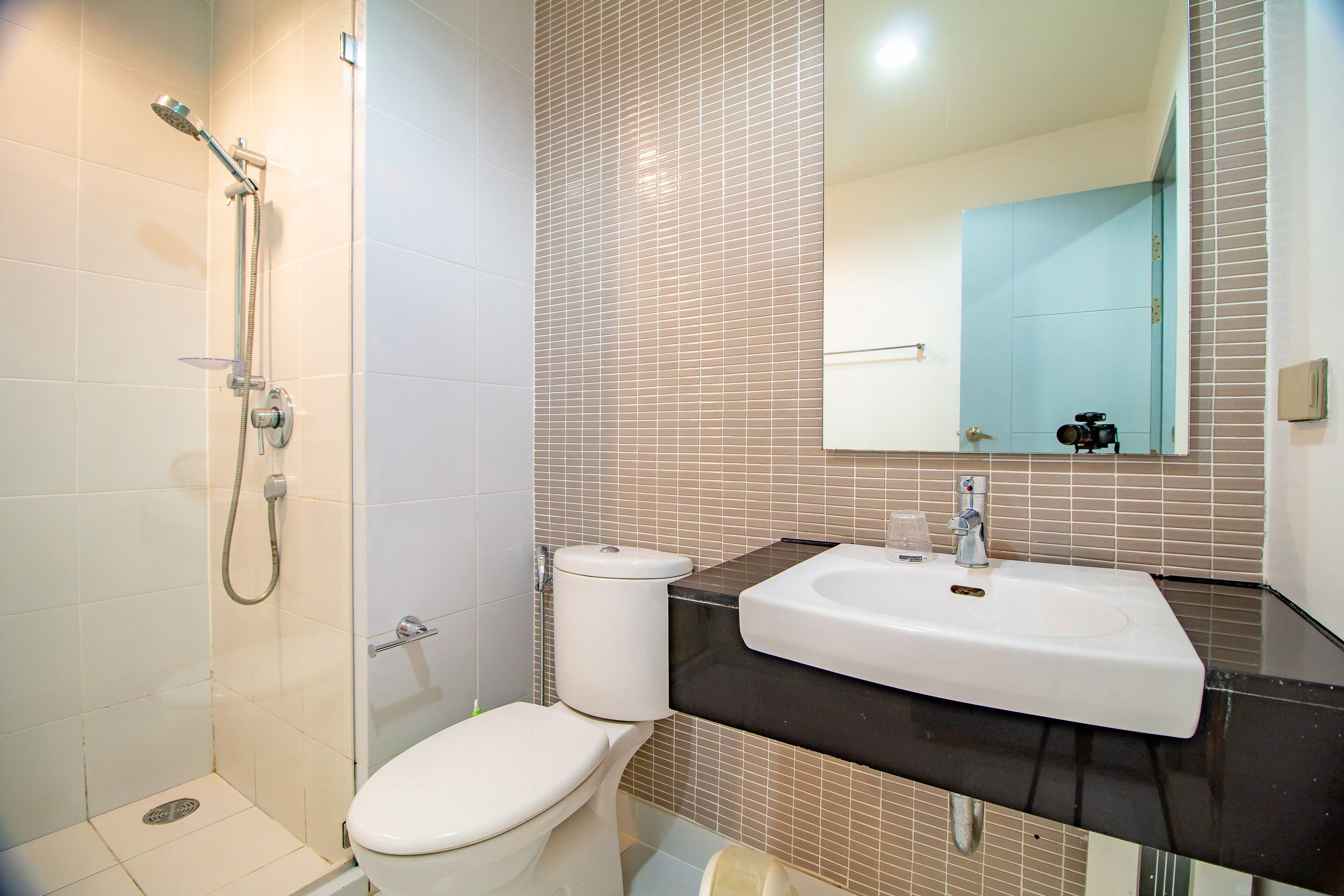 A bathroom with a toilet, sink, and shower.