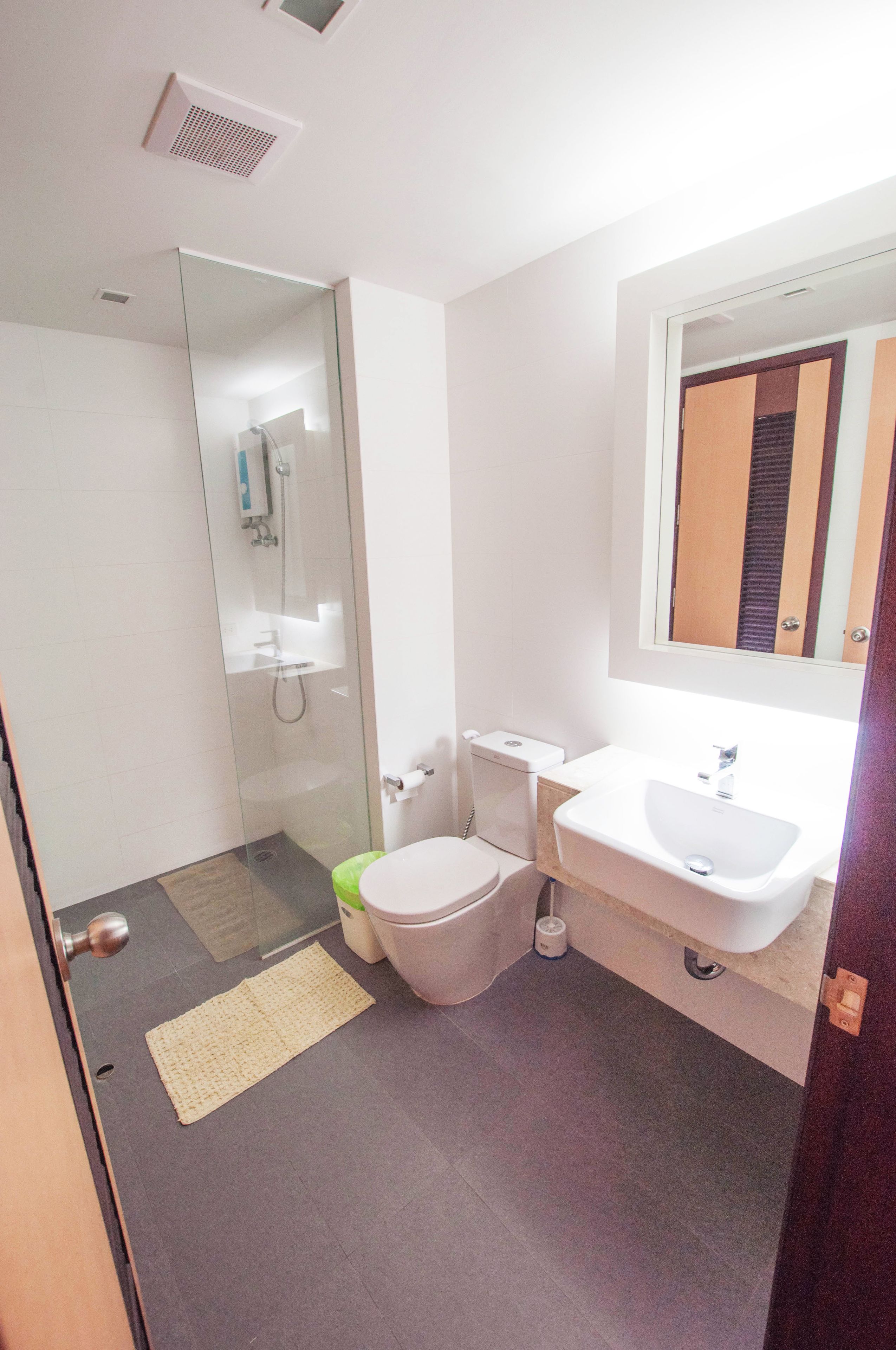 Un baño moderno con cabina de ducha de vidrio, inodoro y lavamanos.