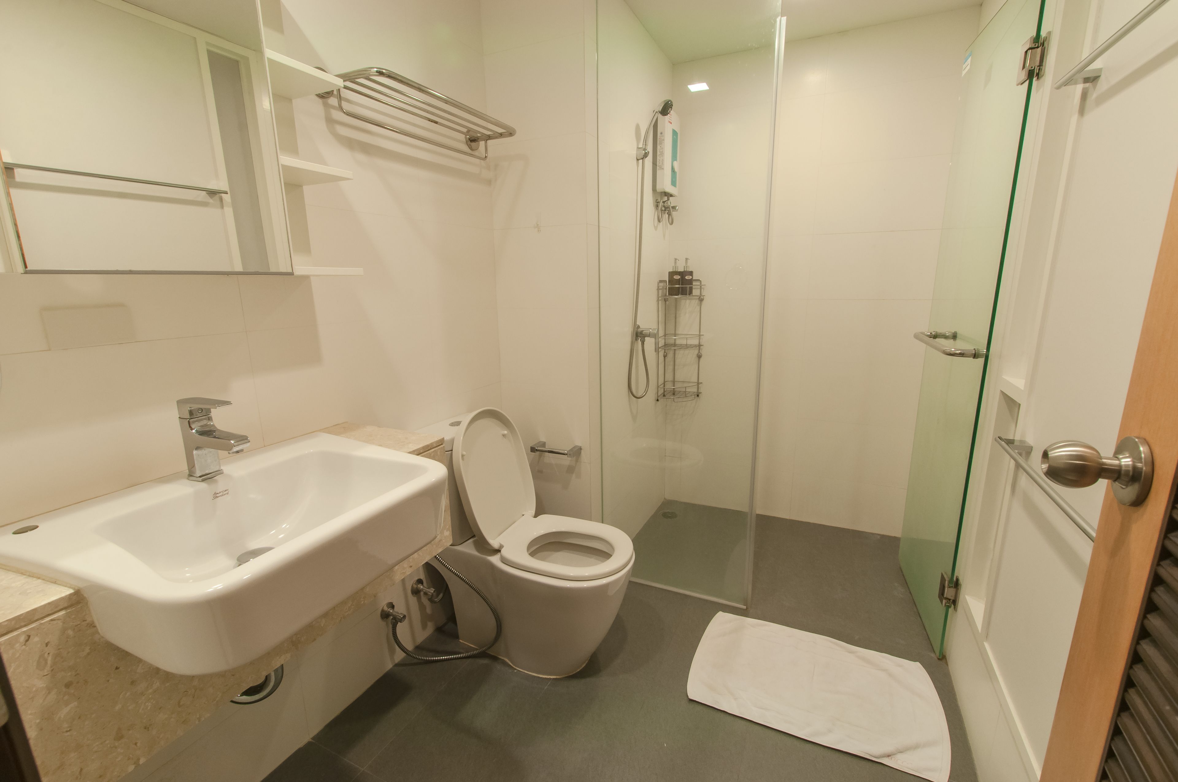 Une salle de bain équipée d’un lavabo, de toilettes et d’une douche à parois de verre.