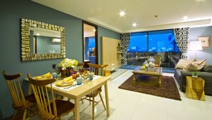 A modern living room with a dining area, featuring a large mirror, a coffee table, and a sofa. - Rocco Hua Hin Beach Seaview (Hua Hin)