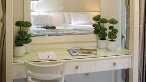 Un dormitorio con una cama, una mesita de noche con lámpara y una ventana con cortinas.