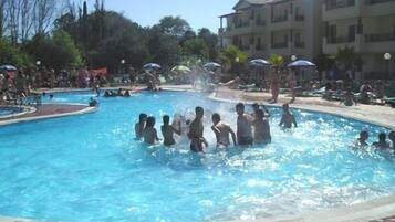 Una piscina al aire libre de temporada, sombrillas