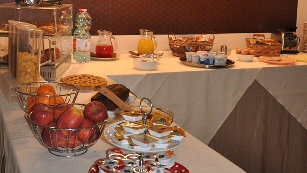 A breakfast buffet with various food items and a wall with coffee-related words. - Le Calandre Hotel (Rubano)