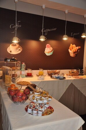 Un buffet de petit-déjeuner proposant une variété d’aliments et un mur décoré d’images sur le thème du café.