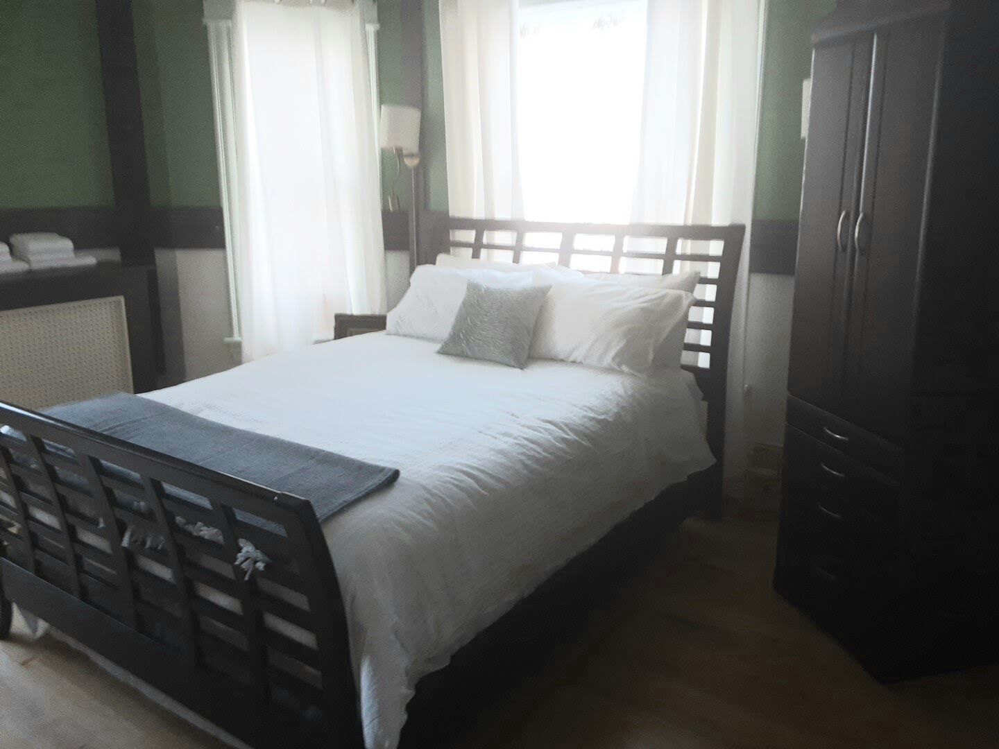 Un dormitorio ordenado con cama, mesita de noche y armario.
