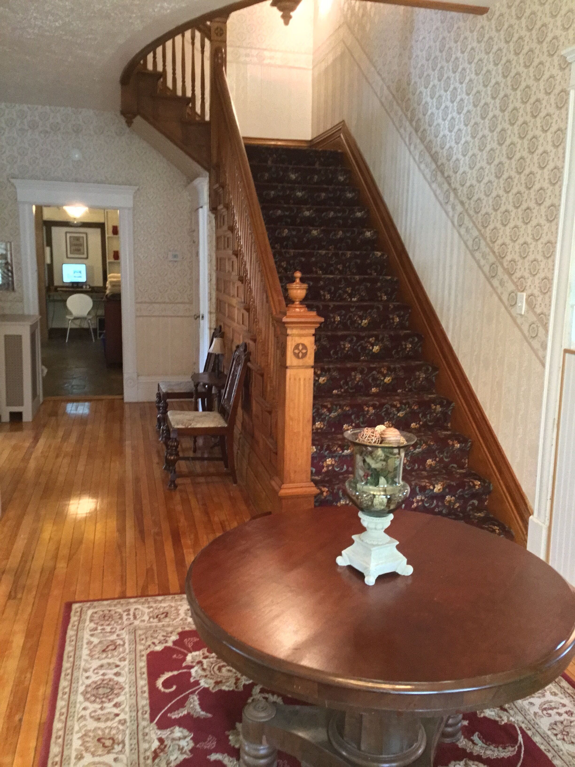 A staircase with wooden railings and a patterned carpet.