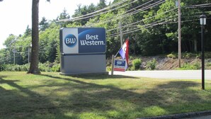 Une enseigne Best Western avec un drapeau et une pancarte indiquant que l’établissement est approuvé par l’AAA (American Automobile Association).