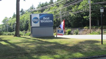 Señal de Best Western con una bandera y un cartel de Alojamiento Aprobado por AAA.