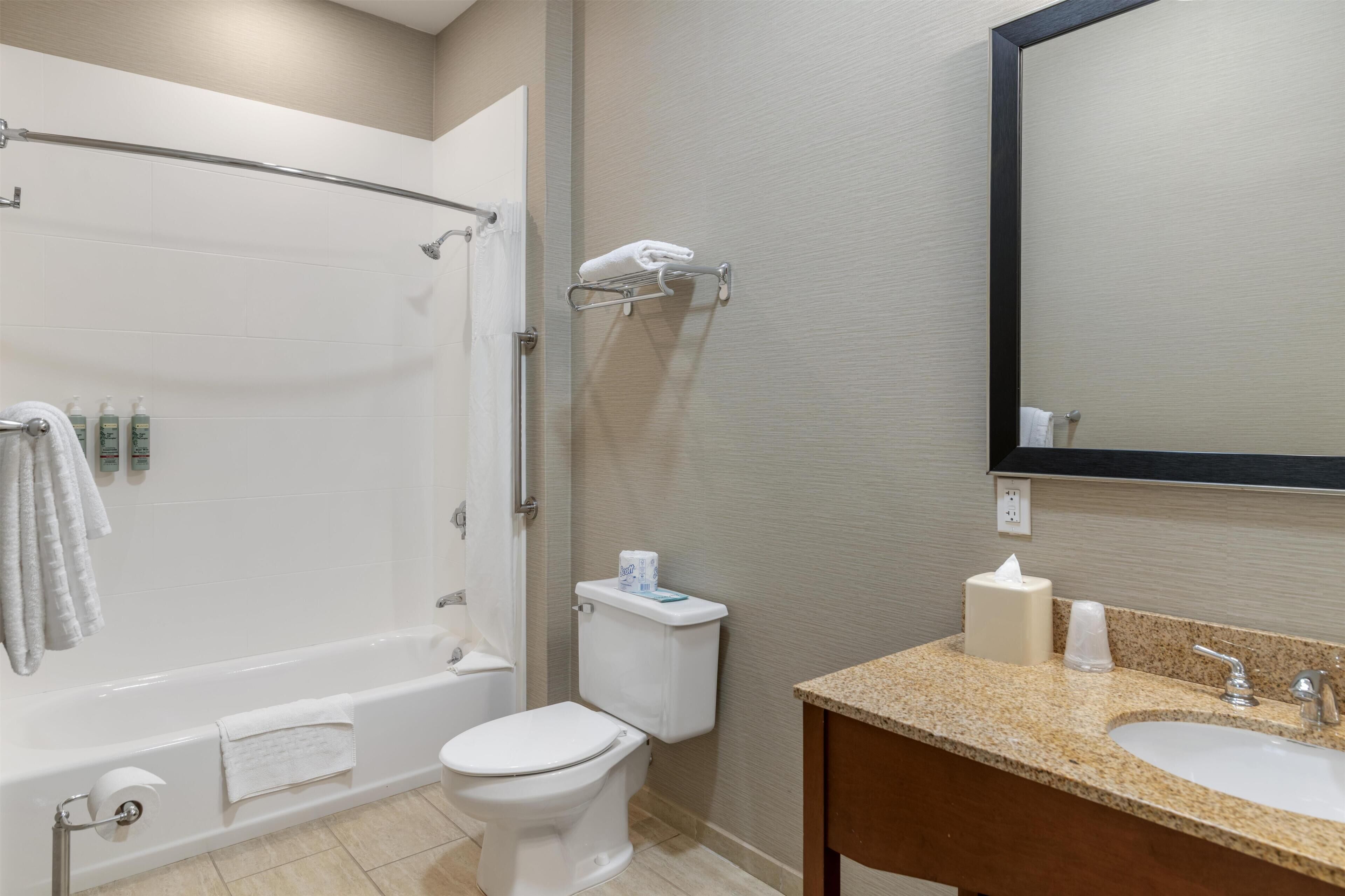 A bathroom with a bathtub, toilet, and sink.