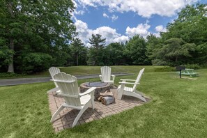 A patio area with Adirondack chairs, a fire pit, and a picnic table. - Best Western Acadia Park Inn (Bar Harbor)