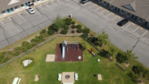 Vue aérienne d’un parking situé à côté d’un bâtiment qui comprend une aire de jeux pour enfants.