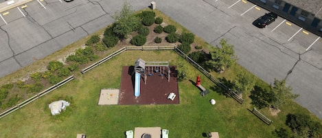 Vista aérea de un estacionamiento junto a un edificio con una zona de juegos.