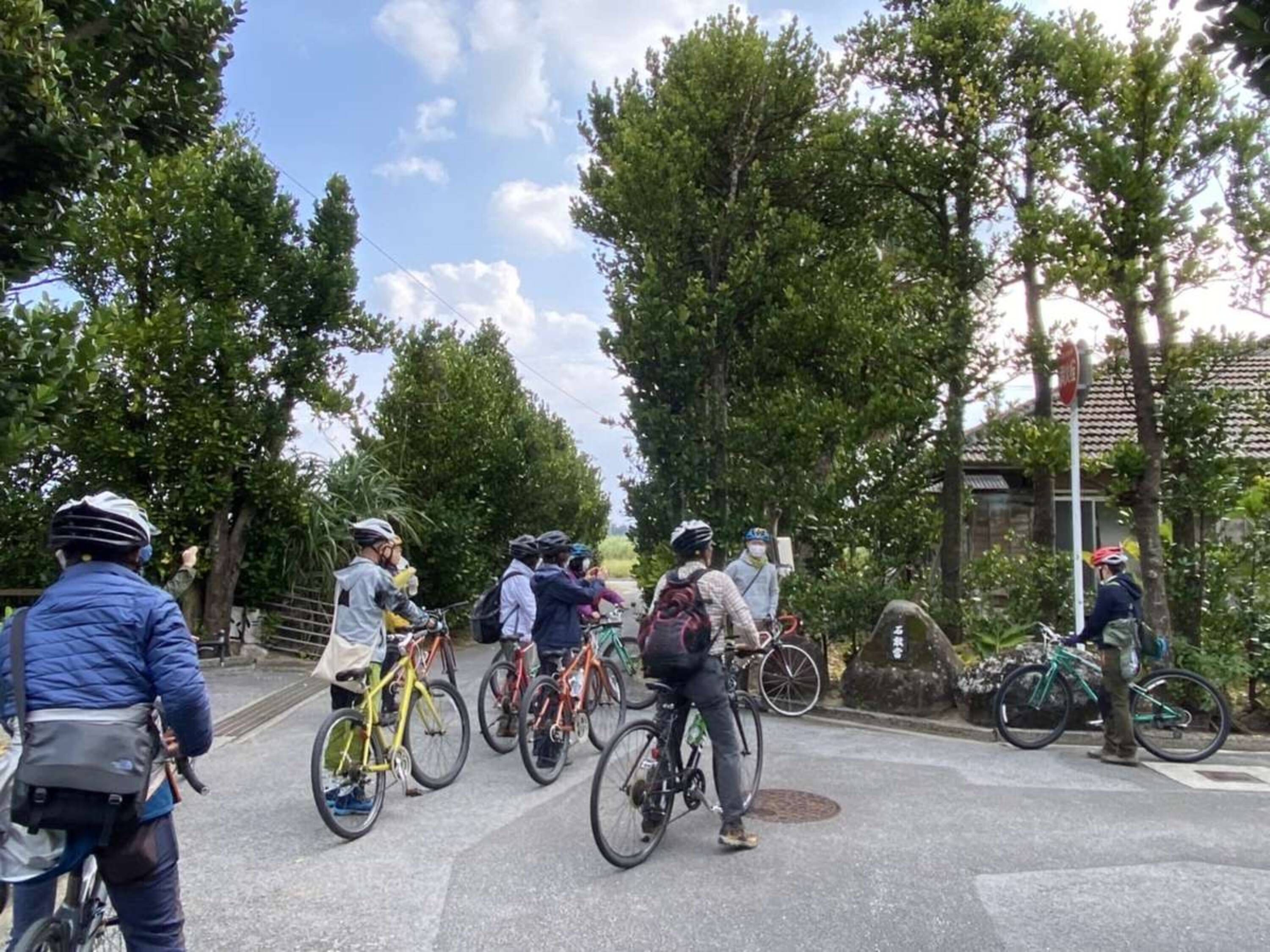 A group of cyclists gathered at a street intersection, possibly waiting for a signal.