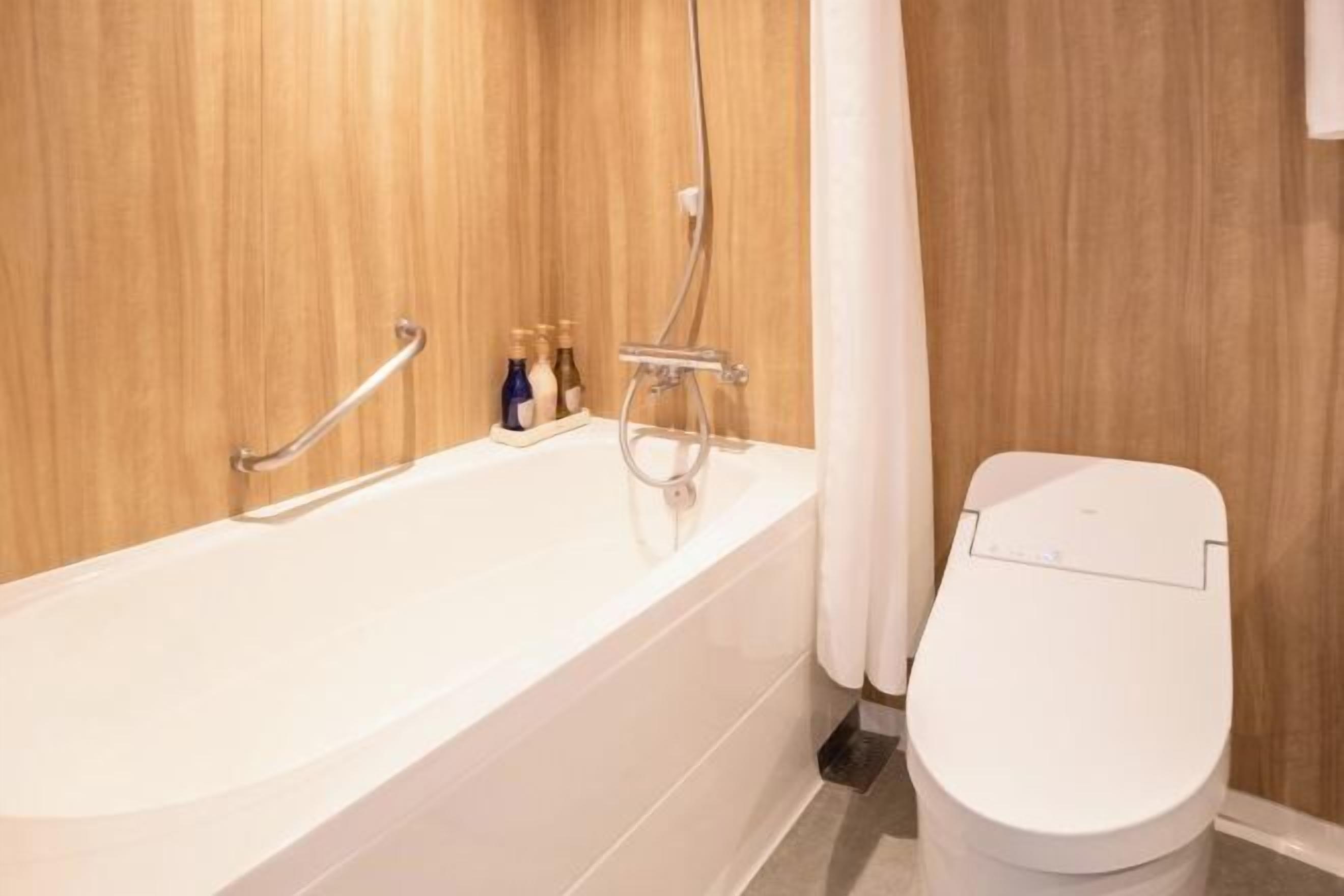 Tina con regadera, secadora de cabello, bidet electrónico, toallas 