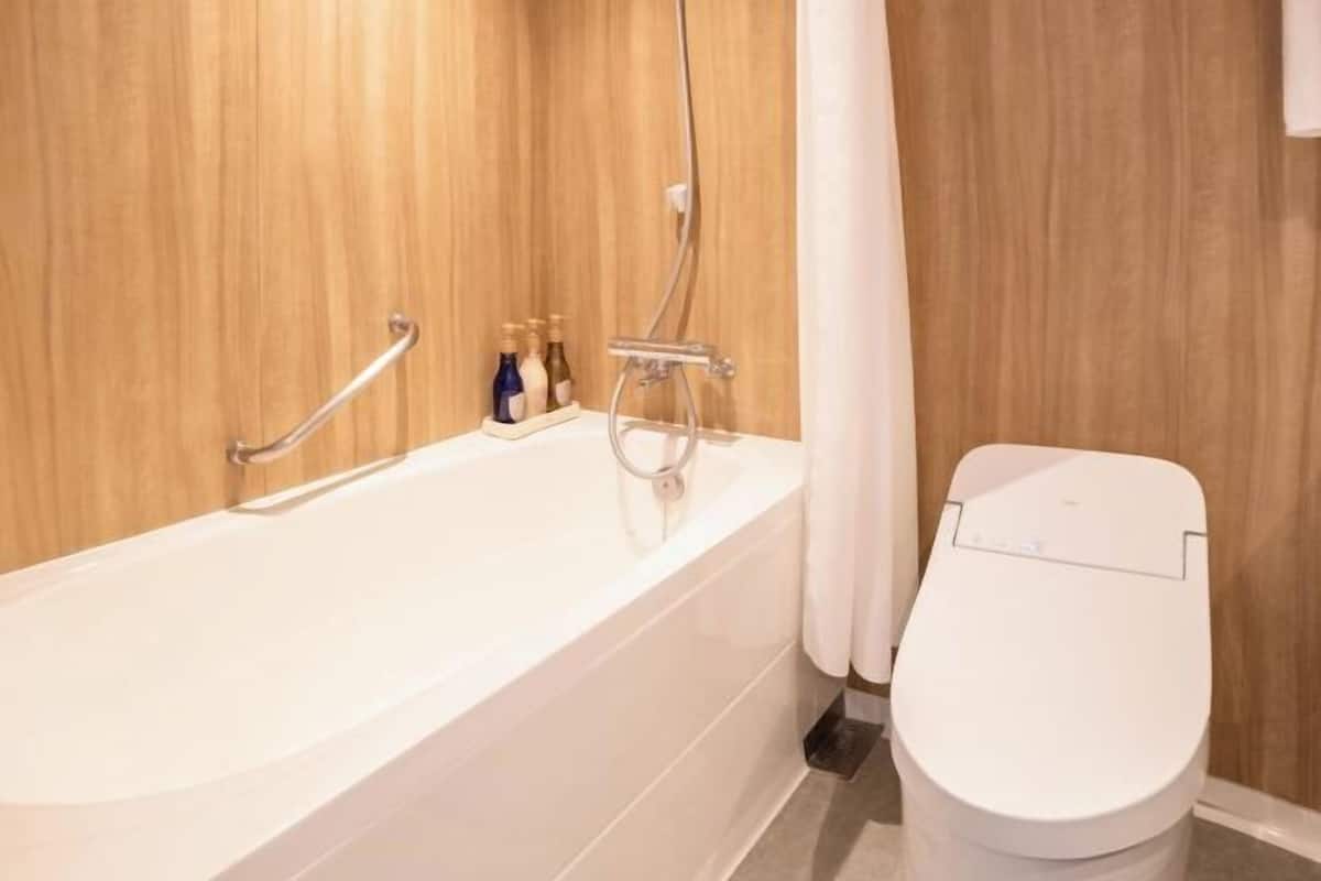 Tina con regadera, secadora de cabello, bidet electrónico, toallas
