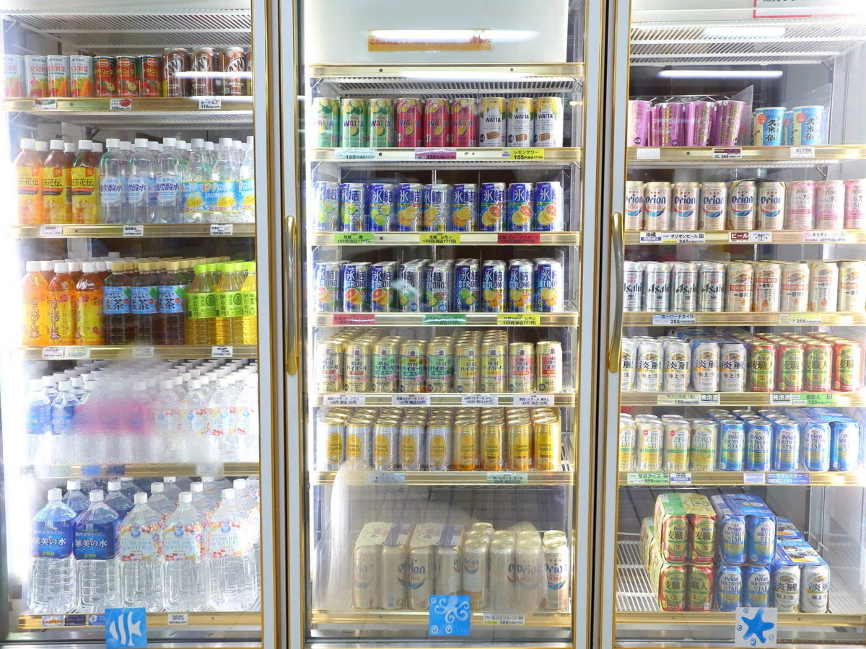A refrigerated display case with various beverages including water, juices, and sodas.
