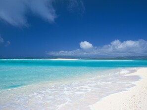 A beach with clear turquoise water and white sand.