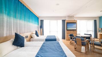 A hotel room with two beds, a desk, and a TV.
