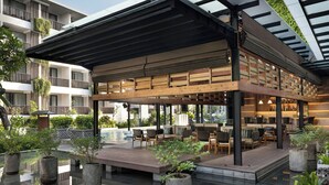 Un espacio moderno al aire libre con piscina, plantas en macetas y un bar junto a la piscina.