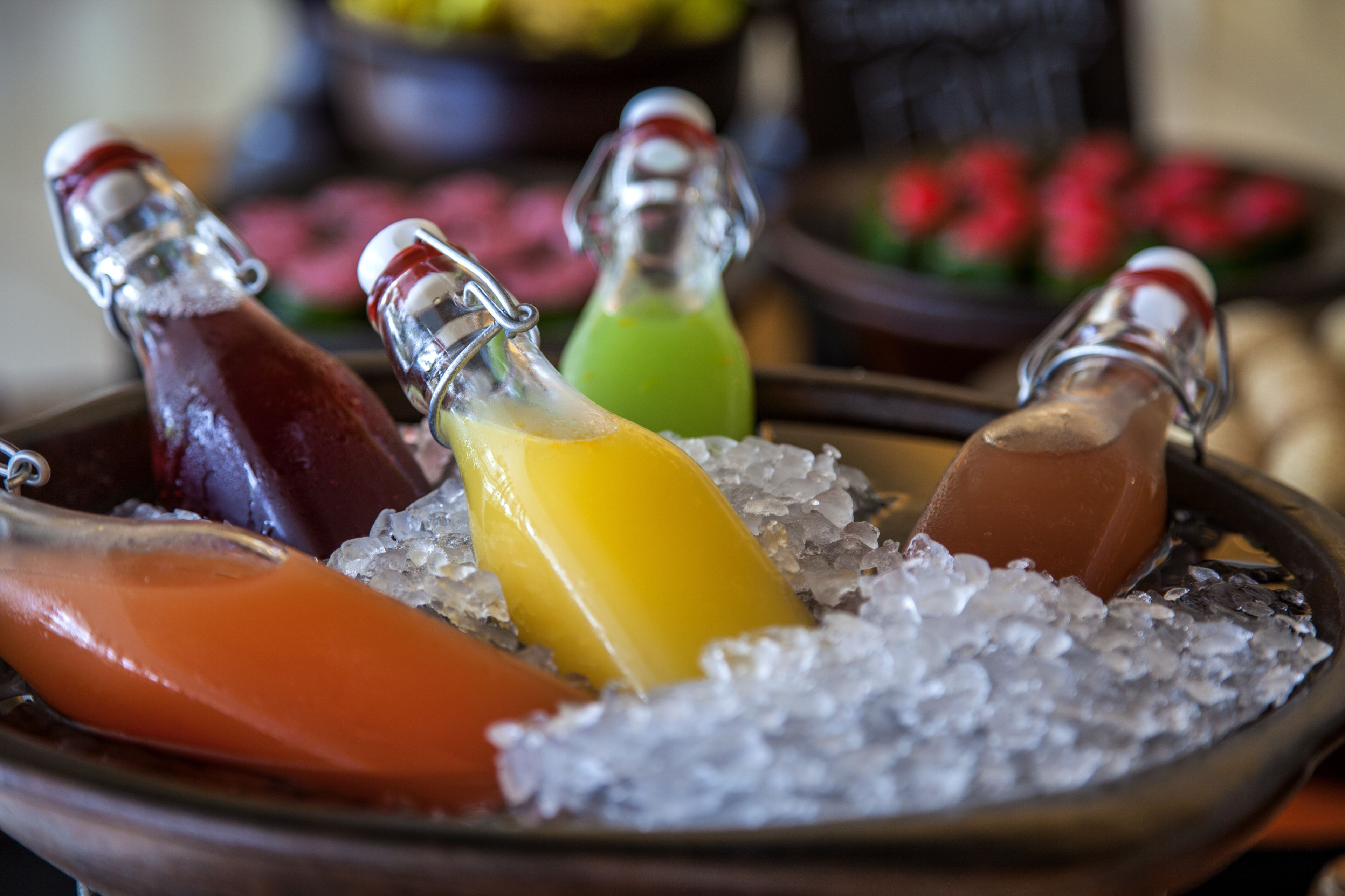 A tray of chilled drinks in bottles on ice.