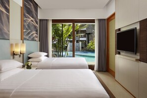 Habitación de hotel con una cama grande, televisión y vistas a una piscina.