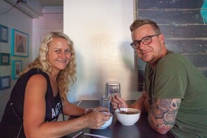 Two people sitting at a table with a bowl of food and a water bottle. - Ocean Island Inn (Victoria)