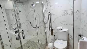 Un baño moderno con ducha de vidrio, inodoro y bidé.