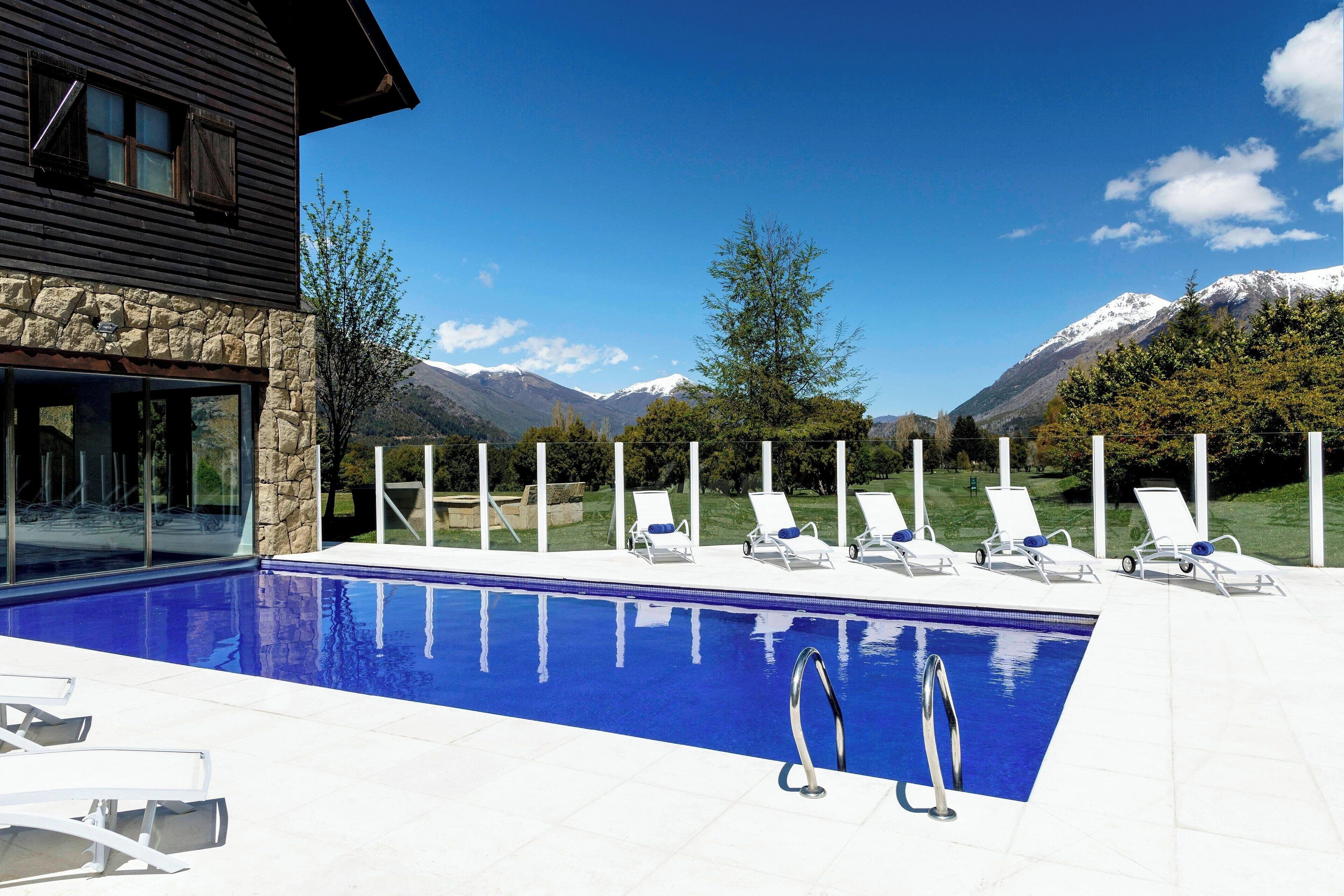 Una piscina techada, sillones reclinables de piscina